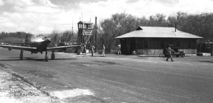 A circa 1943-44 photo of a Bell P-39 taxiing past a temporary wooden control tower & another wooden building at Haleiwa.jpg